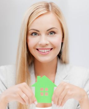 smiling busineswoman with green eco house symbol