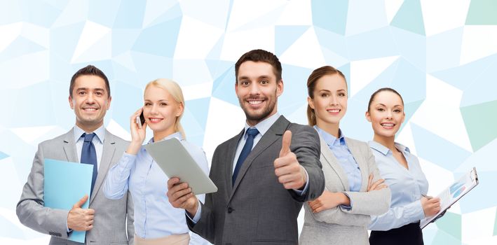 business, people, gesture and office concept - group of smiling businessmen showing thumbs up over blue low poly background