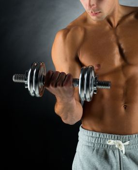 sport, bodybuilding, training and people concept - close up of young man with dumbbell flexing muscles over gray background