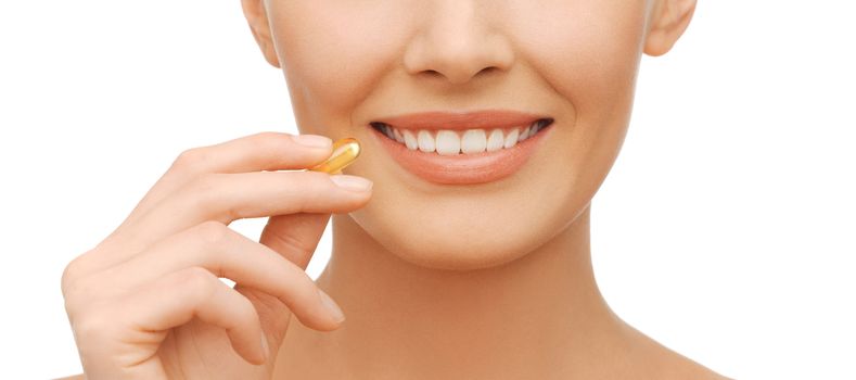 healthcare and beauty concept - beautiful woman with omega 3 vitamins