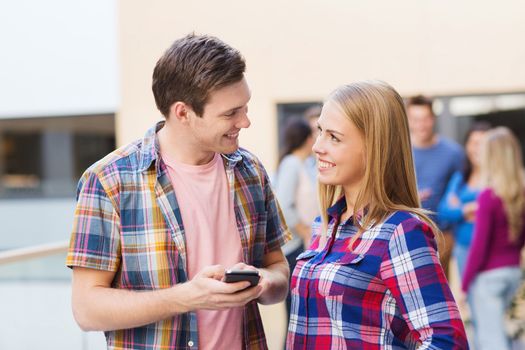 friendship, people, technology and education concept - group of smiling students with smartphone outdoors