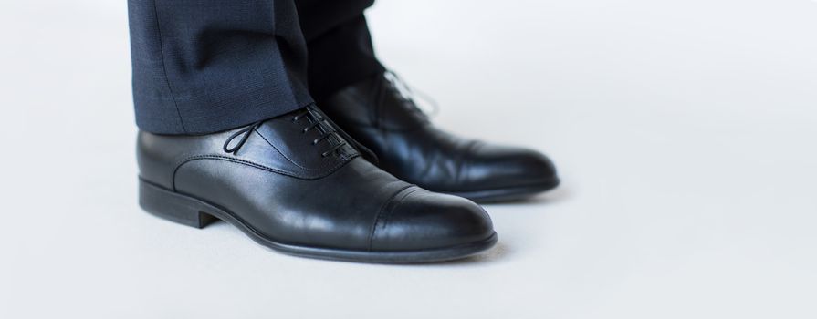 people, business, fashion and footwear concept - close up of man legs in elegant shoes with laces or lace boots