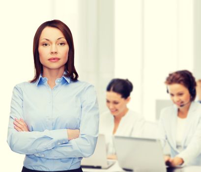 business and education concept - friendly young businesswoman with crossed arms at office