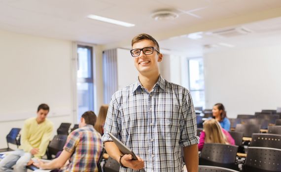 education, high school, teamwork and people concept - group of smiling students with notepads sitting in lecture hall