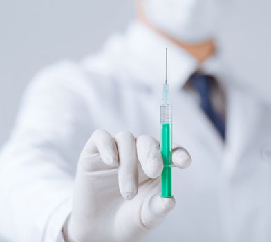 close up of male doctor holding syringe with injection