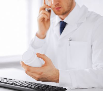 healthcare, hospital and medical concept - male doctor writing prescription paper and capsules