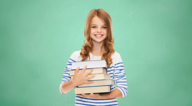 education, people, children and school concept - happy little student girl with many books over green board background