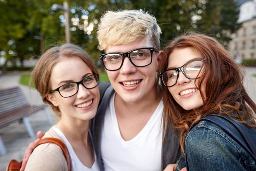 education, friendship, eyesight and teenage concept - group of happy teenage students in eyeglasses at campus