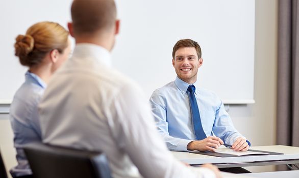 business, people and teamwork concept - group of smiling businesspeople meeting in office