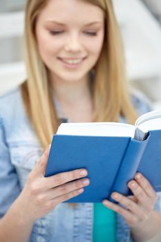 school and education concept - close up of happy young woman reading book at school