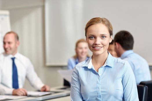 business, people and teamwork concept - smiling businesswoman with group of businesspeople meeting in office