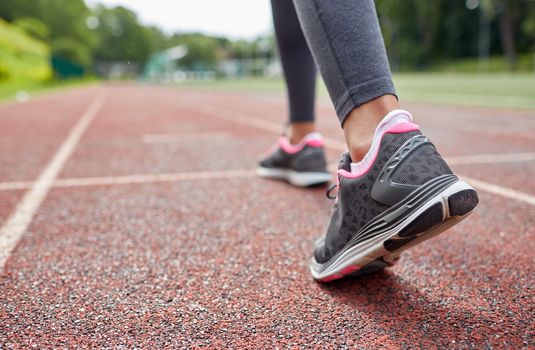fitness, sport, training, people and lifestyle concept - close up of woman feet running on track from back