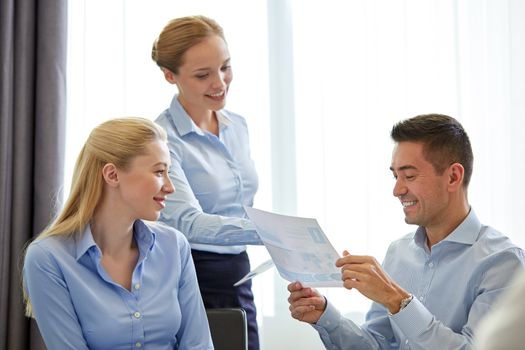 business, people, meeting and teamwork concept - smiling businesswoman giving papers to man in office