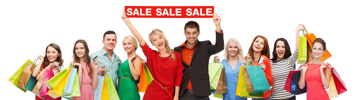 consumerism, people and discount concept - group of happy people with sale sign and shopping bags