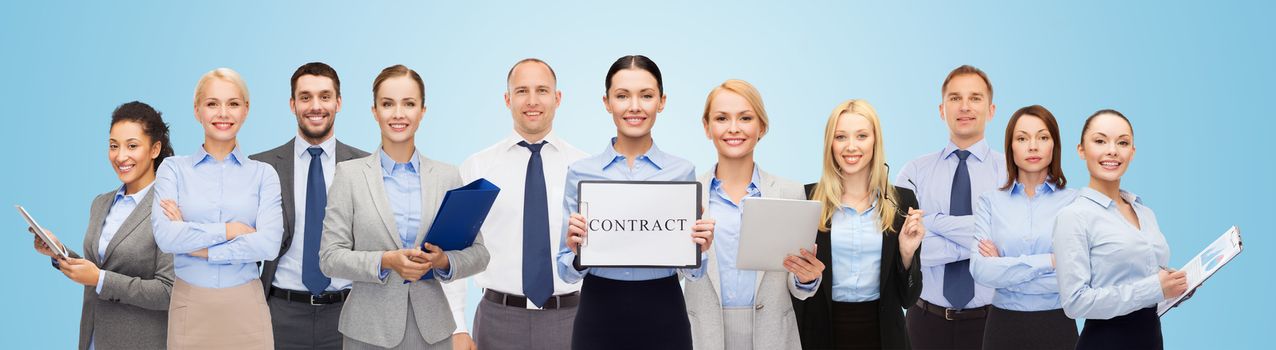 business, people, partnership, work and office concept - group of happy businesspeople holding contract over blue background