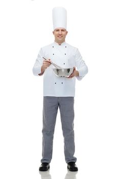cooking, profession and people concept - happy male chef cook holding bowl and whipping something with whisk