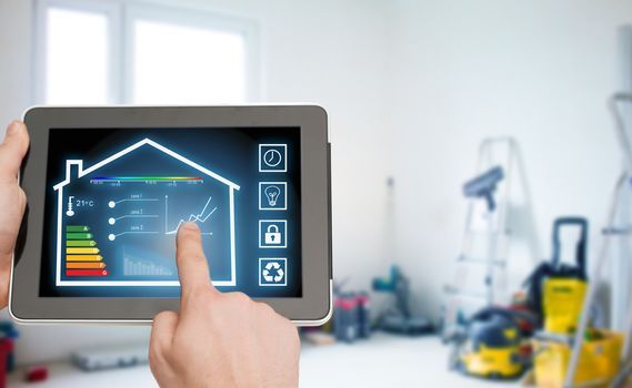 home, housing, people and technology concept - close up of man hands pointing finger to tablet pc computer and regulating room temperature over storeroom or building background