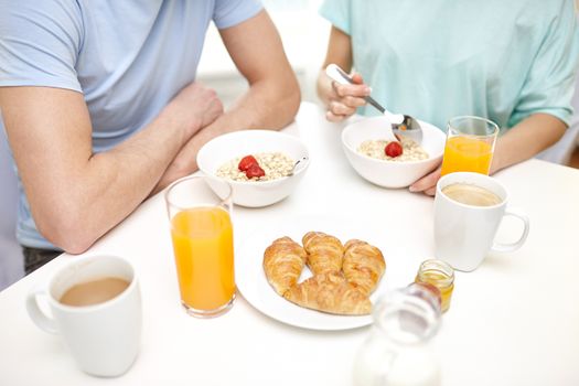 food, eating, people and healthy food concept - close up of couple having breakfast at home