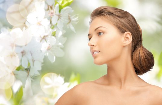 beauty, people and health concept - beautiful young woman face looking aside over green blooming garden background