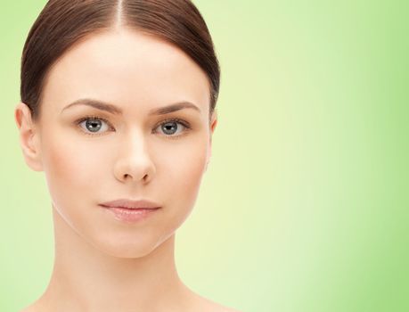 health, people, eco and beauty concept - beautiful young woman face over green background