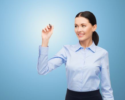 office, business, people and technology concept - businesswoman writing something in air with marker over blue background