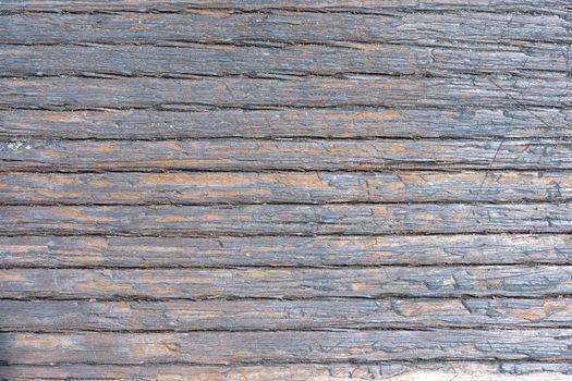 Closeup detail of old weathered and splintered wood showing deep grain and grains of sand and dirt