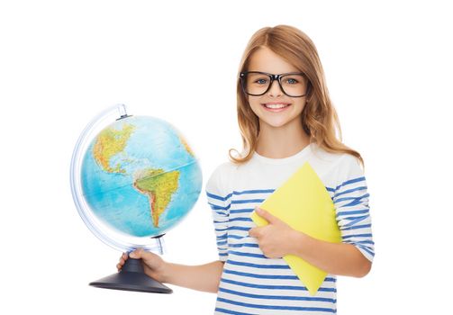 education and school concept - smiling little student girl with globe, notebook and black eyeglasses