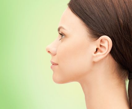 health, people and beauty concept - beautiful young woman face over green background