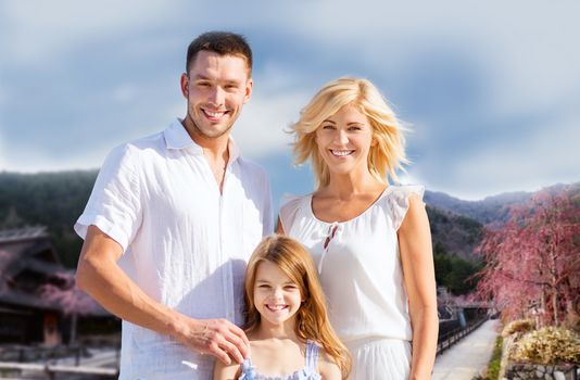 summer holidays, travel, tourism and people concept - happy family over hills background
