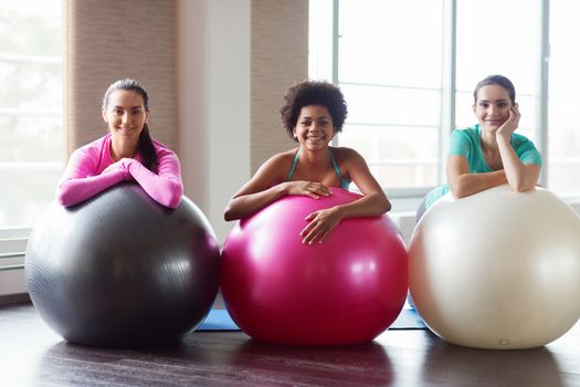 fitness, sport, training and lifestyle concept - group of smiling women with exercise balls in gym