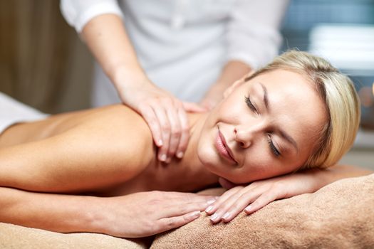 people, beauty, spa, healthy lifestyle and relaxation concept - close up of beautiful young woman lying with closed eyes and having hand massage in spa