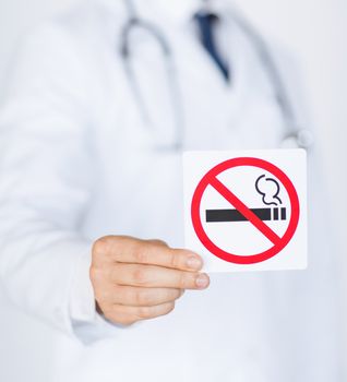 close up of doctor holding no smoking sign in hands