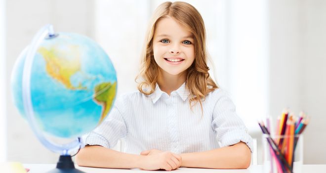 education and school concept - little student girl with globe at school