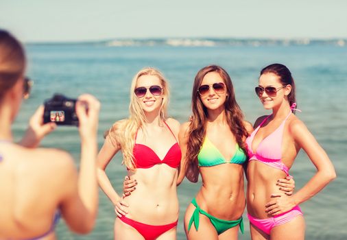 summer vacation, gesture, travel and people concept - group of smiling young women photographing by camera and waving hands on beach