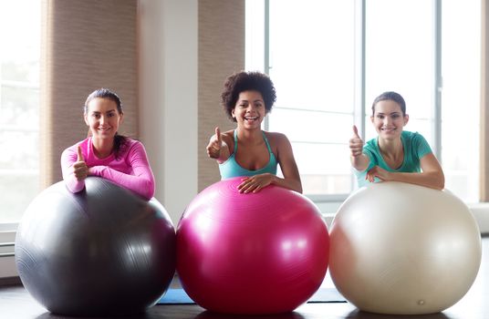 fitness, sport, training and lifestyle concept - group of smiling women with exercise balls in gym