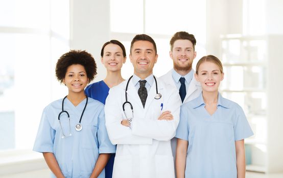 hospital, profession, people and medicine concept - group of happy doctors at hospital