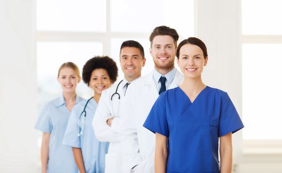 hospital, profession, people and medicine concept - group of happy doctors at hospital