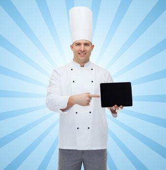 cooking, profession and people concept - happy male chef cook showing tablet pc computer black blank screen over blue burst rays background