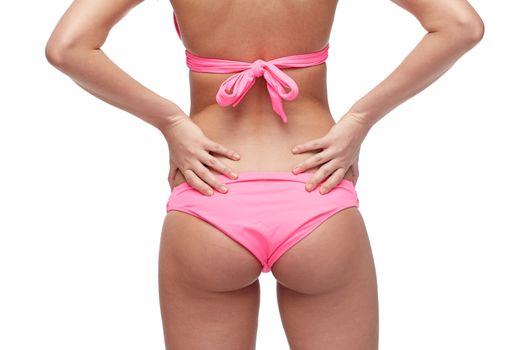 people, fashion, swimwear, summer beach and beauty concept - close up of young woman buttocks in pink bikini