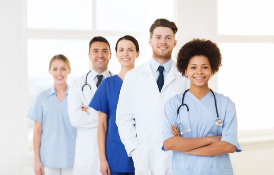 hospital, profession, people and medicine concept - group of happy doctors at hospital