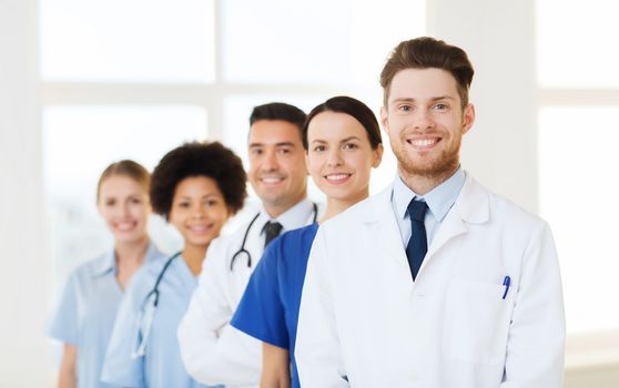 hospital, profession, people and medicine concept - group of happy doctors at hospital