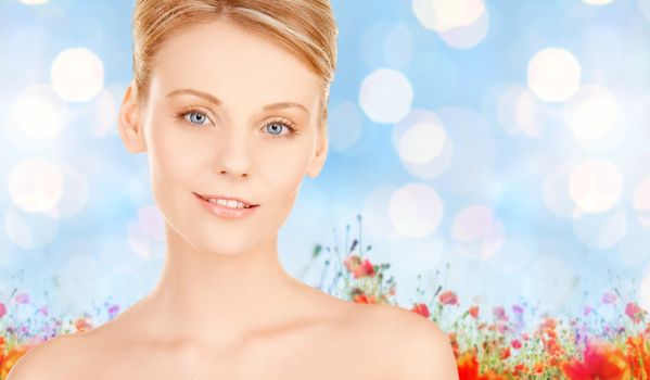 beauty, people and health concept - beautiful young woman face over blue lights and poppy flowers field background