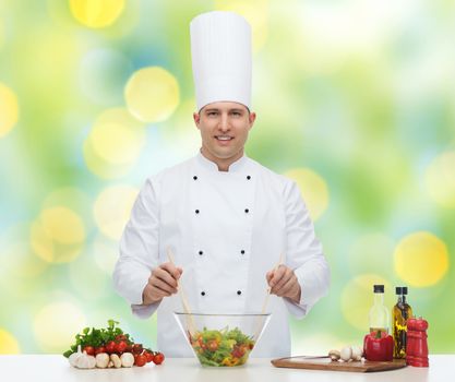 profession, vegetarian, food and people concept - happy male chef cooking vegetable salad over green lights background