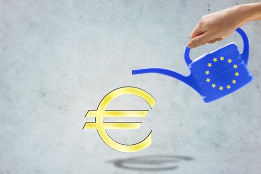 people, economics and europe concept - close up of hand holding watering can with european union stars and euro currency symbol over gray background