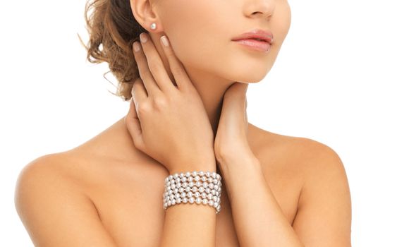 beauty and jewelery concept - beautiful woman with pearl earrings and bracelet