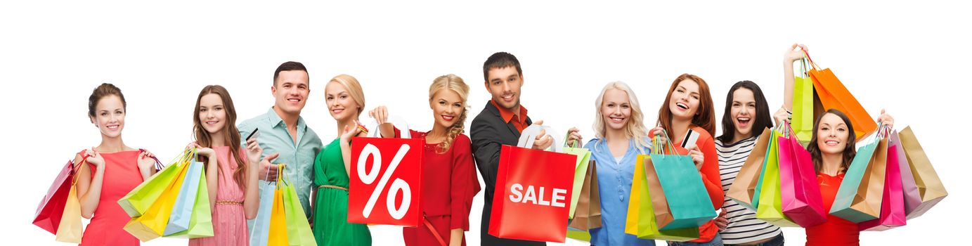 consumerism, people and discount concept - group of happy people with percentage and sale sign on shopping bags