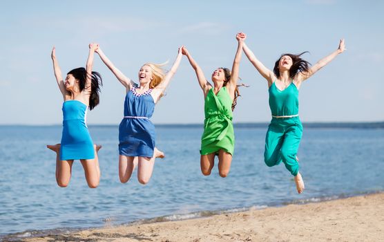 summer holidays and vacation - girls jumping on the beach