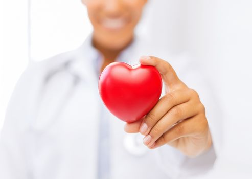 health and charity concept - close up of woman hand holding heart