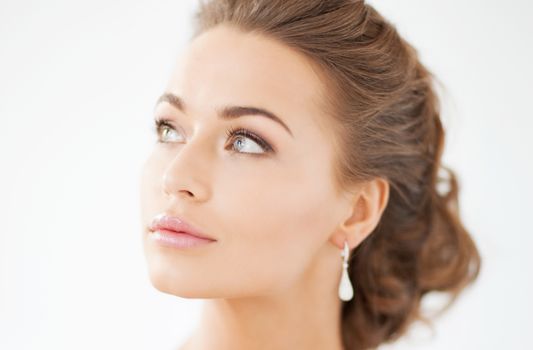 beautiful woman in white dress and diamond earrings