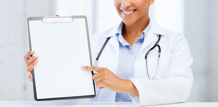 health care and medical concept - female doctor with stethoscope and blank prescription